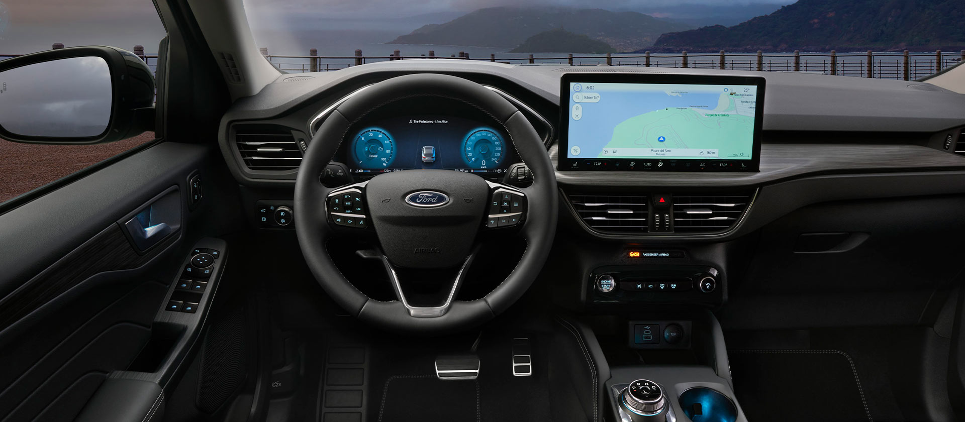 Interiér samonabíjecího hybridního vozu Ford a obrazovka navigace ve vozidle.