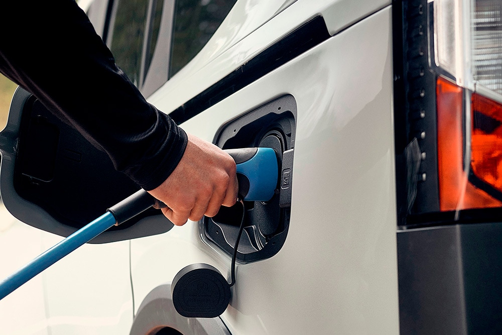 Osoba připojující elektromobil Ford k nabíjecímu kabelu elektromobilu.