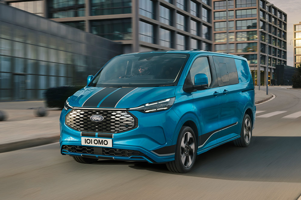 Modrý Ford E-Transit Custom DCiV projíždí ulicí.