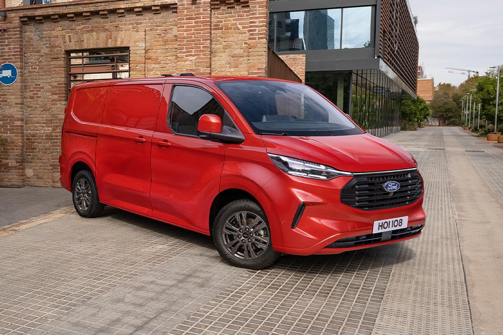 Červená dodávka Ford Transit Custom zaparkovaná na ulici ve městě.